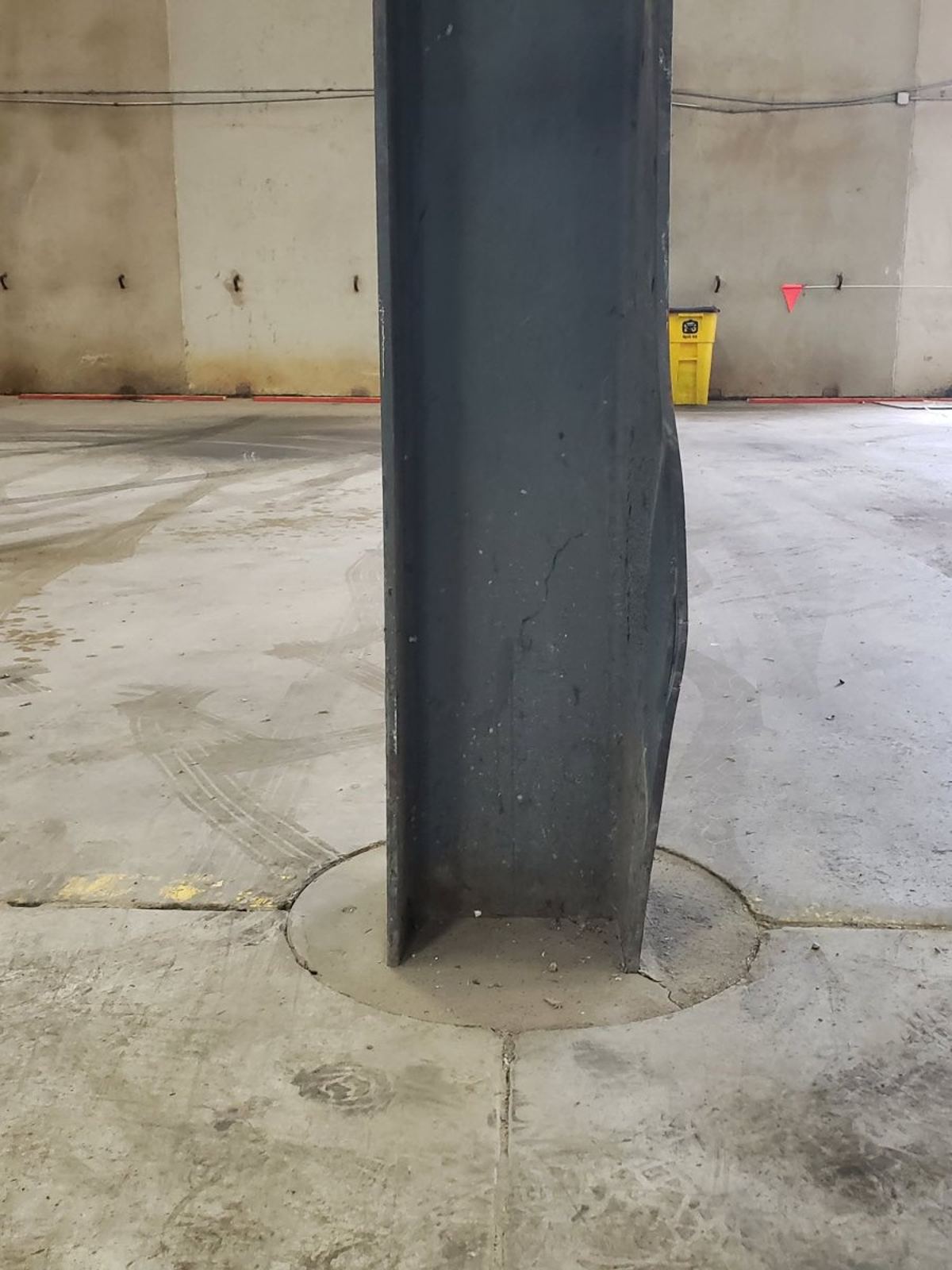 Structural steel beam bent out of line after a forklift strike inside an operating plant