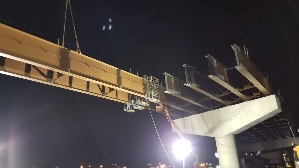 Crane setting a bridge beam at night