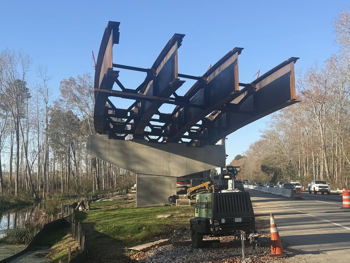 Steel bridge girders being set over a highway