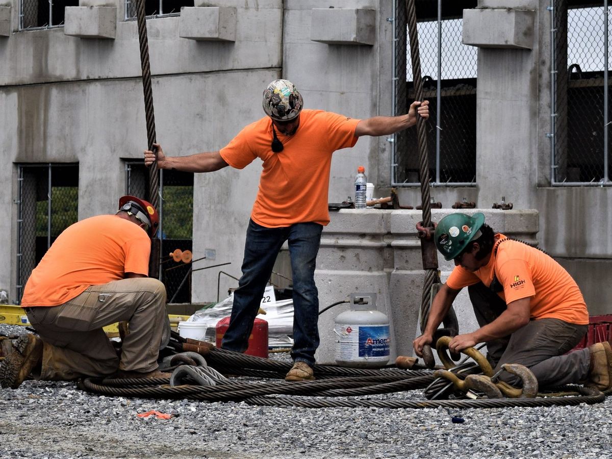 HSE ironworkers laying out wire rope slings and hooks at a precast structure