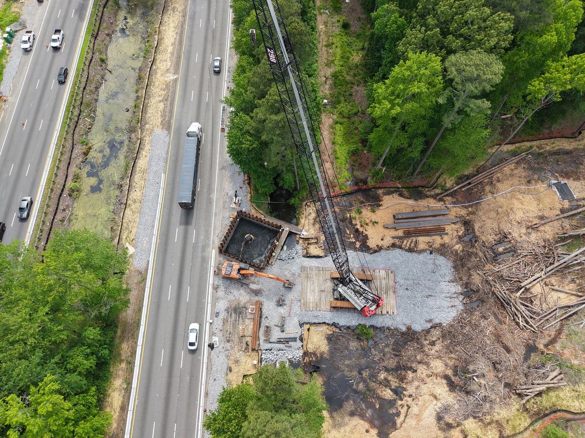 Aerial view of bridge foundation work beside a live highway