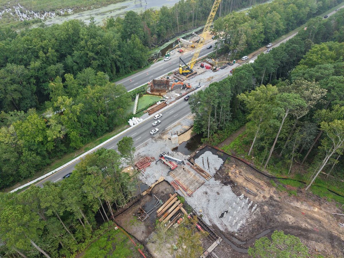 Aerial view of a bridge erection site beside a highway
