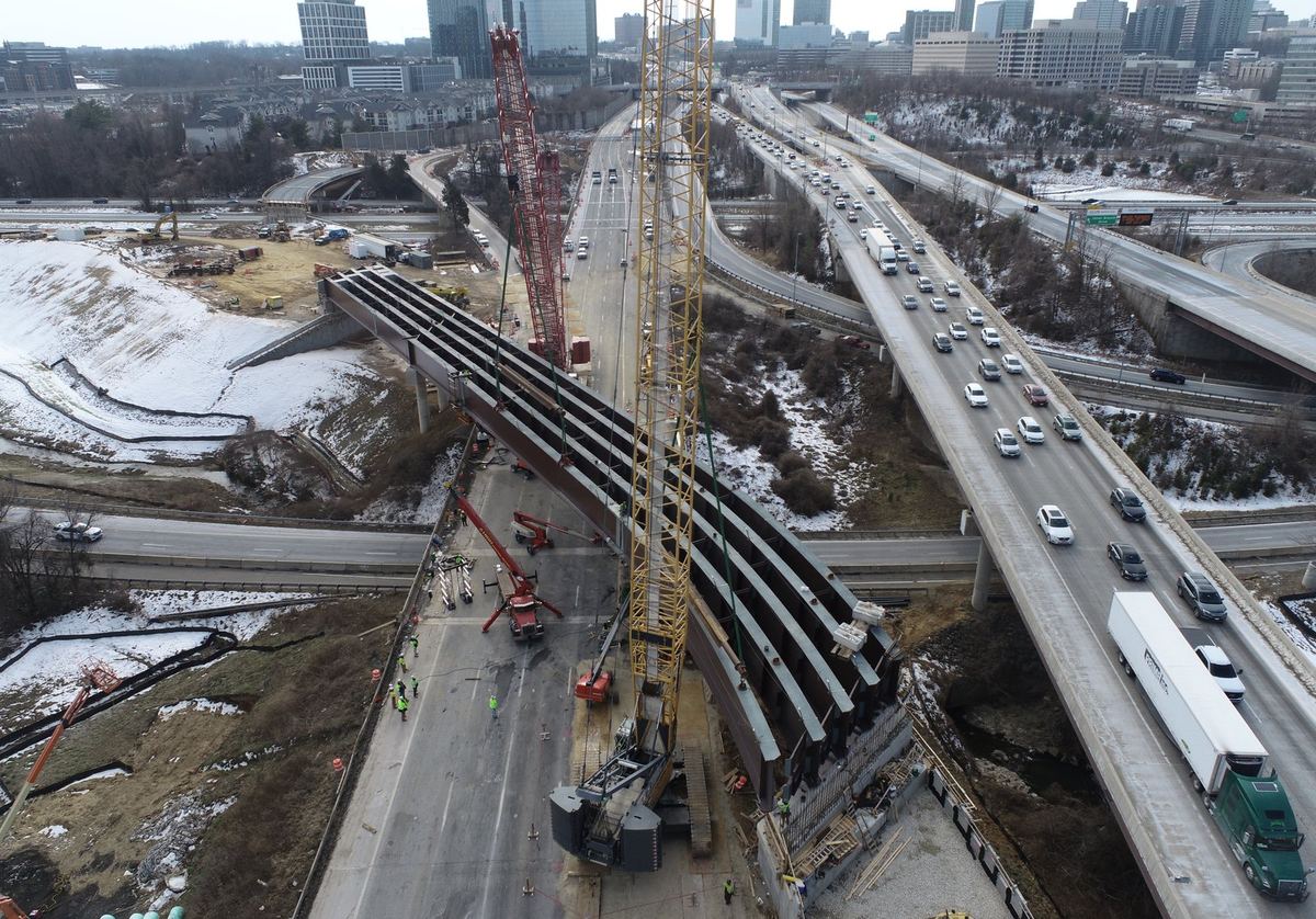 Aerial view of a crane setting bridge girders over a live interstate