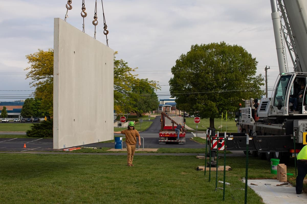Precast concrete wall panel being lifted into place by crane