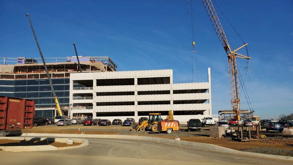 Precast parking structure erected beside an office building under construction