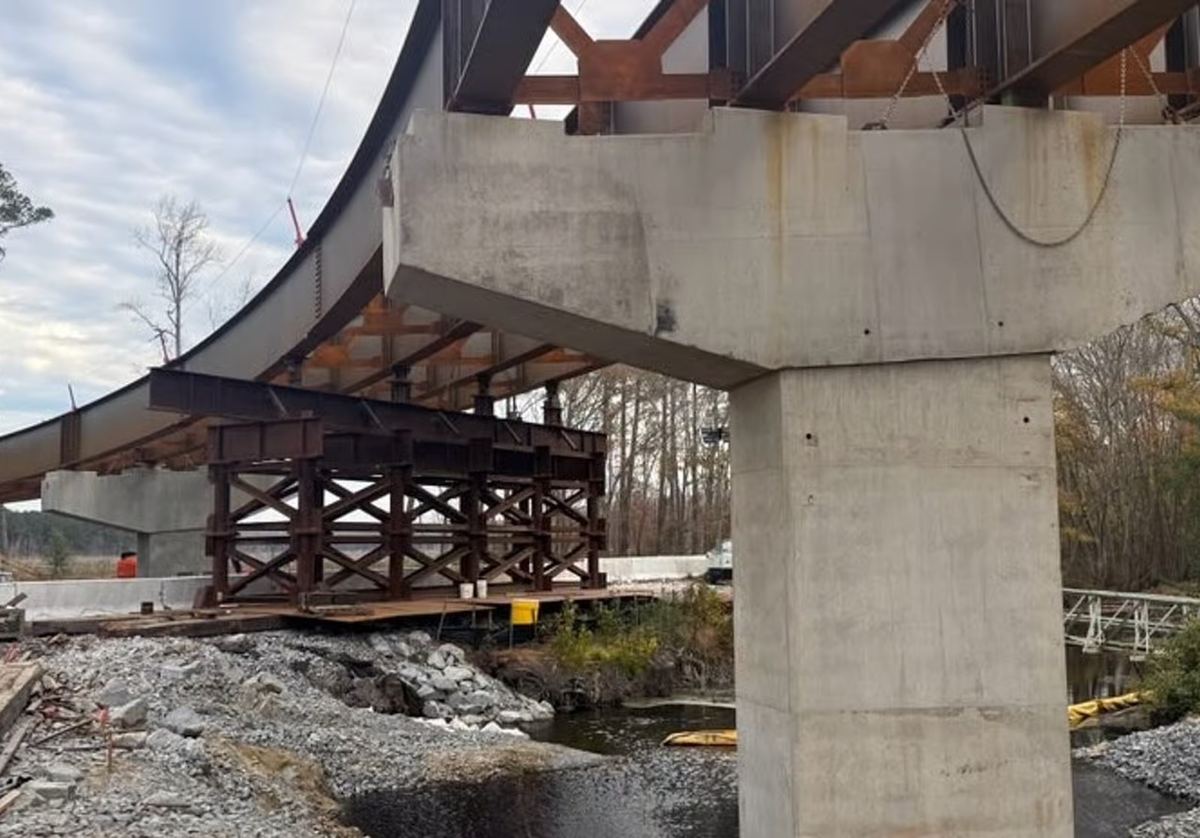 Jacking towers and falsework supporting a curved steel girder at a bridge pier