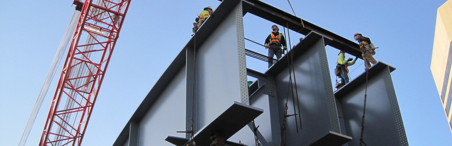 HSE ironworkers setting a curved plate girder section with a crawler crane