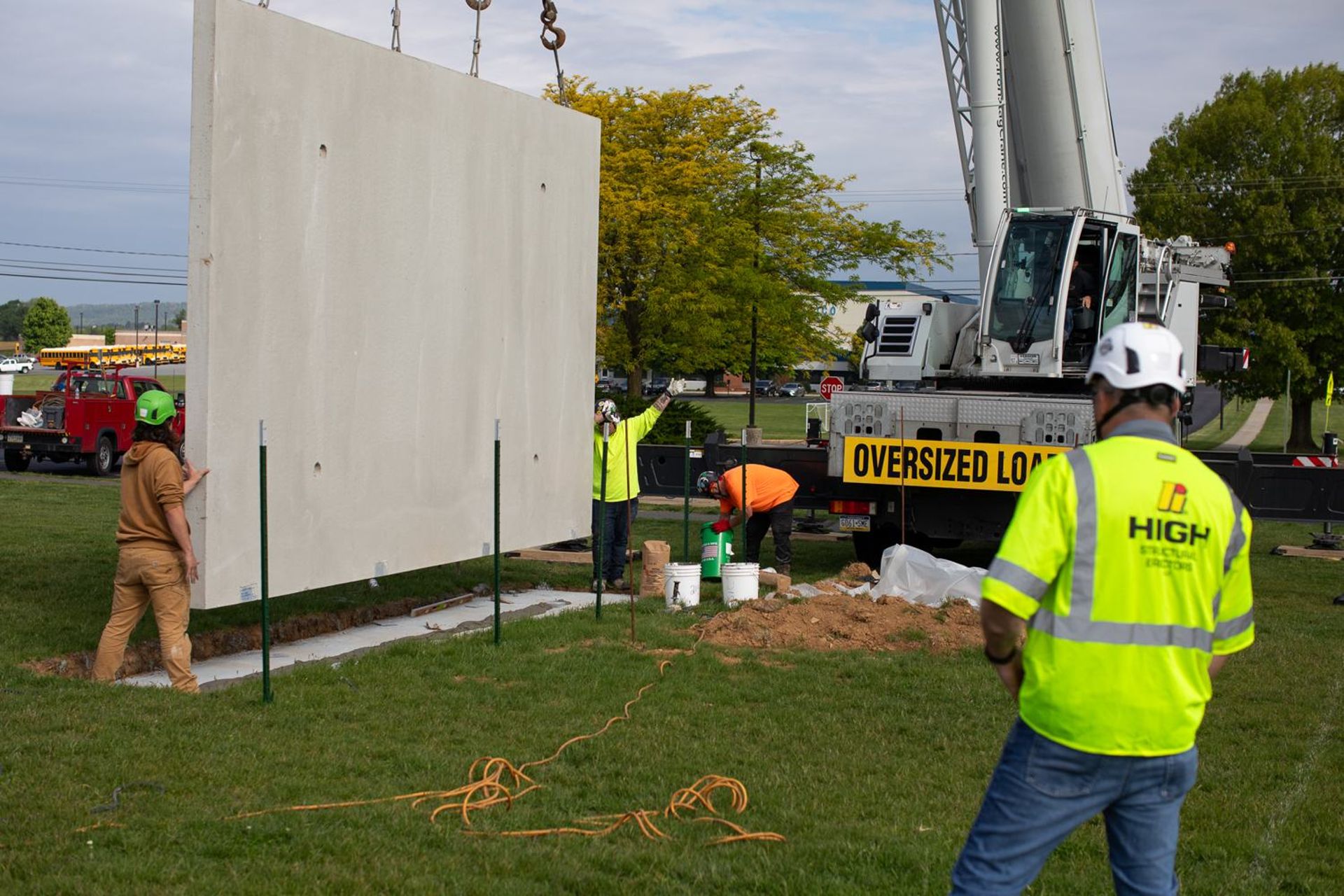 HSE crew setting a precast wall panel on its foundation