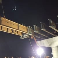 Crane setting a bridge beam at night