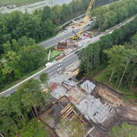 Aerial view of a bridge erection site beside a highway