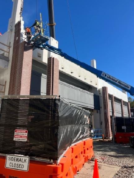 HSE ironworkers in a manlift setting brick faced precast cladding on the Dover Mobility Hub