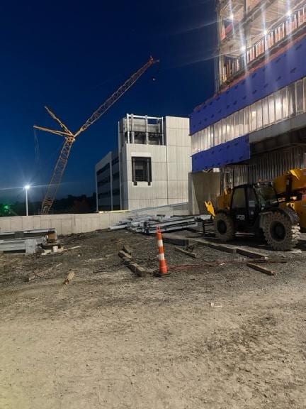 Crawler crane beside the Geisinger garage tower at dusk