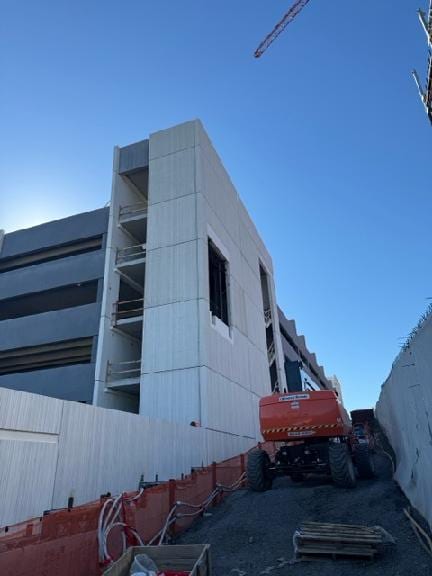 The completed precast tower at the Geisinger parking garage under a clear blue sky