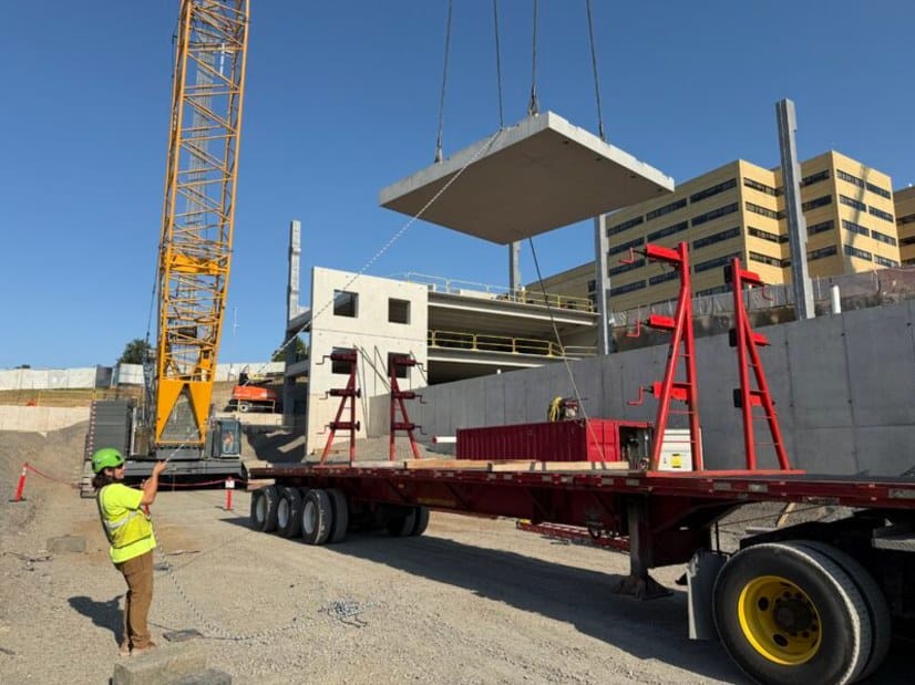A precast deck member lifted from the trailer as the first bay of the garage rises
