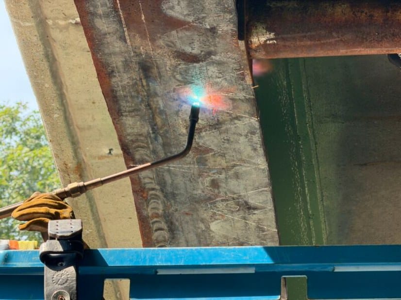 Heating torch applied to the web of a damaged steel girder