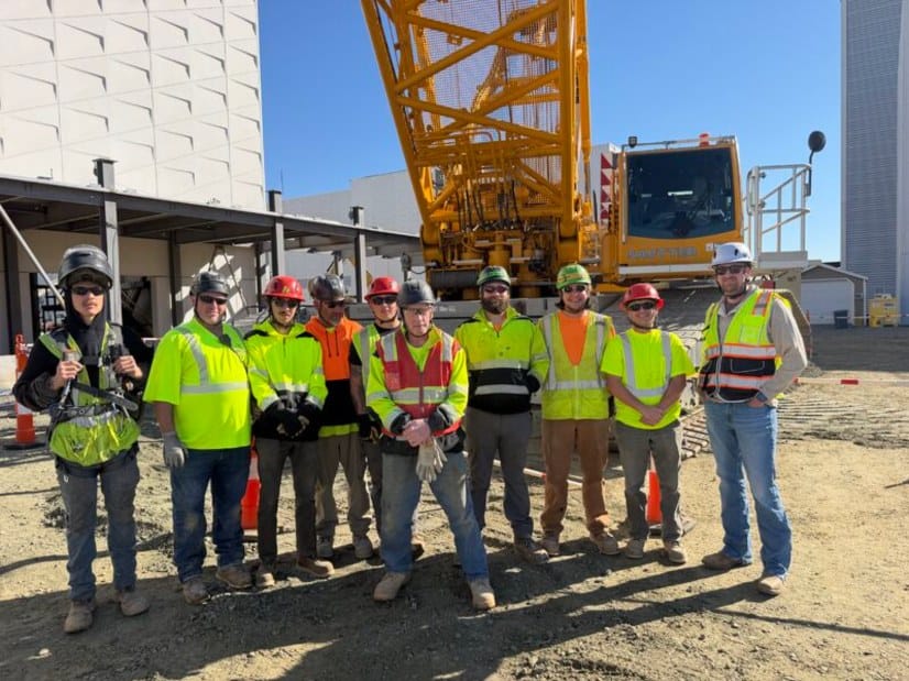 The HSE precast panel crew in front of a crawler crane