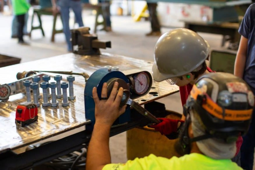 Campers in hard hats running a bolt torque test with an HSE ironworker